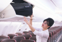 Seorang pramugari Lion Air meletakan bagasi penumpang. Foto ilustrasi