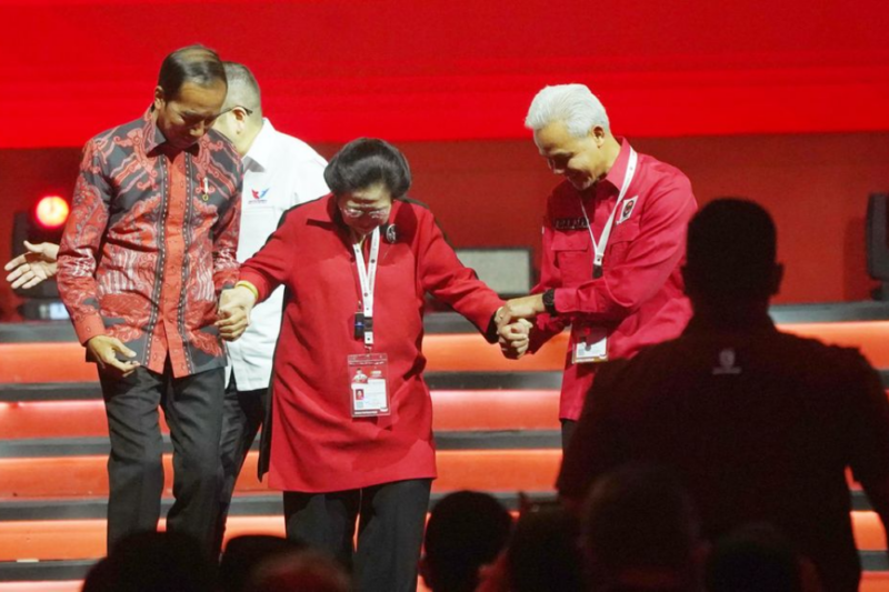 Presiden Jokowi dan Ganjar Pranowo menggandeng tangan Ketua Umum PDIP Megawati Soekarnoputri. Foto: Kompas.id