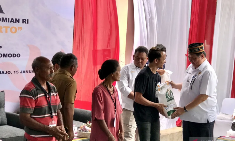 Menko Bidang Perekonomian Airlangga Hartarto (kanan) menyerahkan bantuan pangan berupa beras 10 kilogram kepada warga di Gudang Bulog Batu Cermin, Manggarai Barat, Nusa Tenggara Timur, Senin (15/1/2024). Foto: Antara