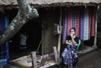 Seorang perempuan Sasak duduk di depan rumah tenun. Foto ilustrasi: Project Multatuli.