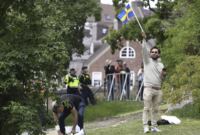 Salwan Momika melambaikan bendera Swedia di luar kedutaan besar Irak di Stockholm, pada 20 Juli 2023, di mana ia berencana untuk membakar salinan Al-Quran dan bendera Irak. Foto: AP via Daylisabah